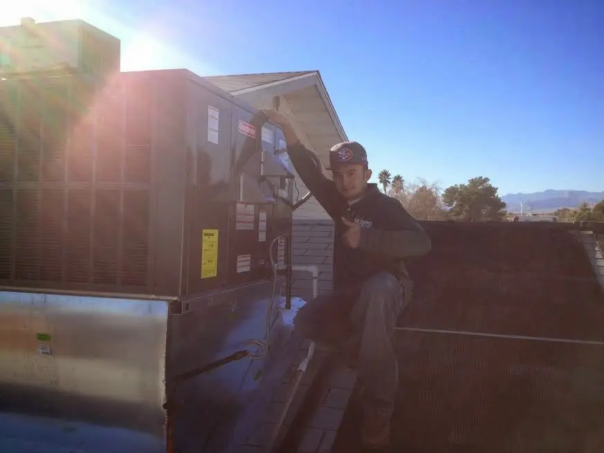 HVAC technician performing AC Tune-Up on a rooftop unit in Martinez